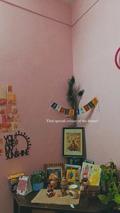 a room with pink walls and pictures on the wall