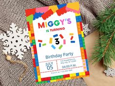 a birthday party card with legos on it and snowflakes in the background