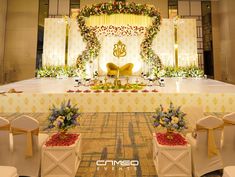 an elaborate stage set up with chairs and flowers on the floor for a wedding ceremony