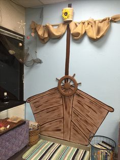 a boat made out of cardboard sitting on top of a table next to a basket