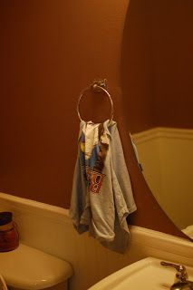 a bathroom with a sink, mirror and towel rack on the wall next to it