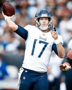 a close up of a football player holding a ball in the air with one hand