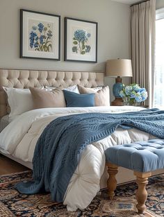 a large bed with blue and white comforter in a bedroom next to a window