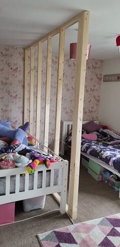 two beds in a room with pink and white wallpaper