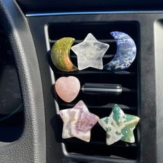 the car dashboard is filled with different kinds of stars and moon magnets on it