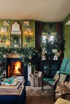 a living room filled with furniture and a fire place covered in christmas greenery next to a window