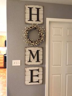 the wall is decorated with wooden letters that spell home and wreath hanging on it's side