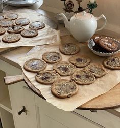 some cookies are sitting on a table next to a tea pot