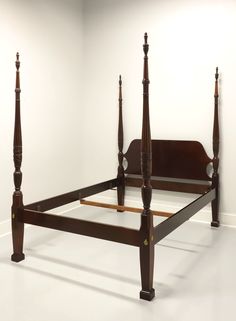 a bed with wooden posts in an empty room