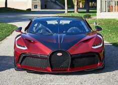 a red and black bugatti parked in front of a house