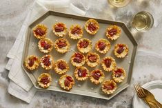 small pecan tarts on a platter with goldware