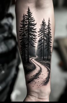 a man's arm with a black and white forest scene on it
