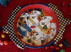 this is a plate decorated with horses and checkered table cloth on a red surface