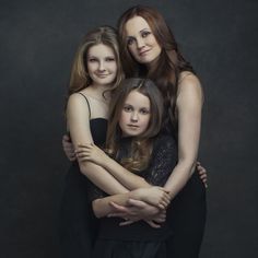 three women are hugging each other in black and white