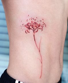 a flower tattoo on the side of a woman's lower back ribcage