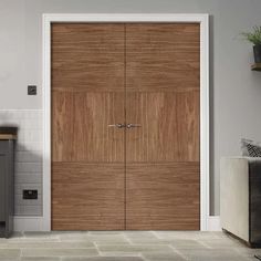 an open wooden door in a room with tile flooring and white tiles on the walls