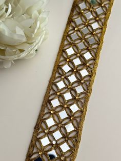 a white flower sitting on top of a table next to a gold and glass tie