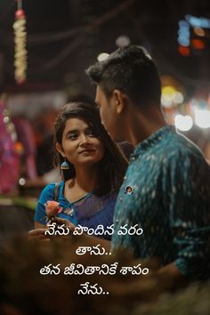 a man and woman standing next to each other in front of a street at night