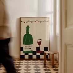 there is a poster with a wine bottle on it next to a chair and table