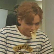 a man eating something in his mouth while wearing a striped shirt