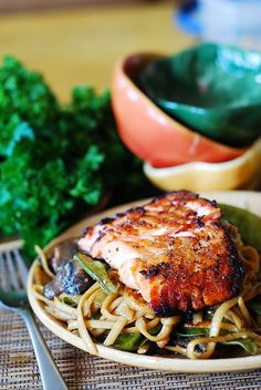 a plate with noodles, meat and vegetables on it