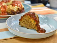 a piece of meatloaf on a plate next to some other plates with food