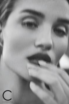 a black and white photo of a woman brushing her teeth