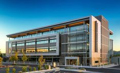 an office building with many windows on the front and side of it, along with parking lot