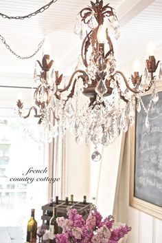 a chandelier hanging from the ceiling in a room with chalkboard on the wall