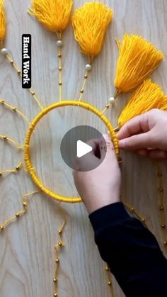 someone is making some yellow tassels out of string and beads on the table