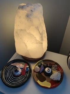 three plates with rocks on them next to a lite - up rock and bowl