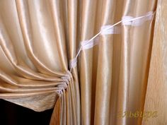 the curtain is pulled down and tied to the side by a white string with an arrow on it