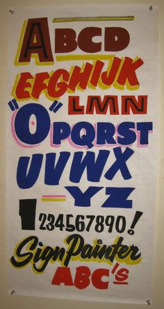 a poster with different types of letters and numbers on it's back side, hanging from the wall