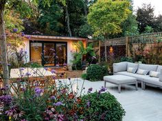 an outdoor living area with couches and flowers