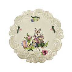 a white doily with an image of a bunny and flowers on the side, in front of a white background