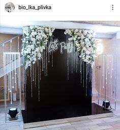 a black wall with white flowers and icing on the side, next to some stairs