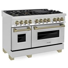 a white stove top oven with two burners on each side and gold knobs