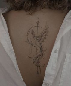 the back of a woman's neck with a bird tattoo on it