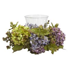 a glass vase filled with purple and green flowers