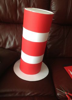 a red and white striped cup sitting on top of a brown couch