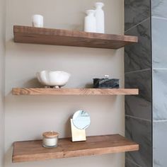 two wooden shelves in a bathroom with soap, toothbrushes and other items on them