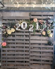 two wooden crates with flowers and balloons on them that spell out the word sisqs