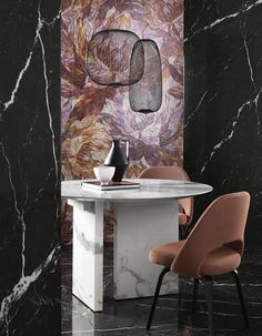 a dining room table with chairs and a vase on it, in front of a marble wall