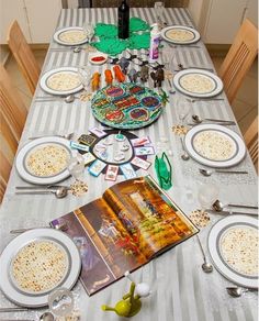 the table is set with plates, silverware and an open cookbook on it