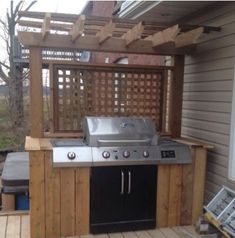 an outdoor bbq with grill built into the side of it and covered in wood planks