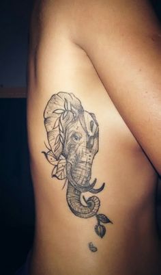 an elephant tattoo on the back of a woman's left arm and shoulder, with leaves around it