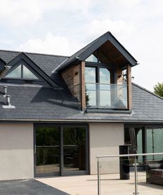 a modern house with large windows and black roof