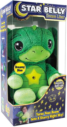 a green stuffed animal with stars on it's chest in a cardboard packaging box