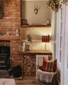 a living room filled with furniture and a fire place in front of a brick wall