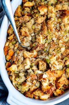 a casserole dish with stuffing in it and a spoon resting on the side